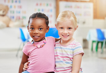 Portrait, girls and children in classroom for diversity, daycare education or learning with friends. Kindergarten, students and kids hug with child development or confidence at school for knowledge