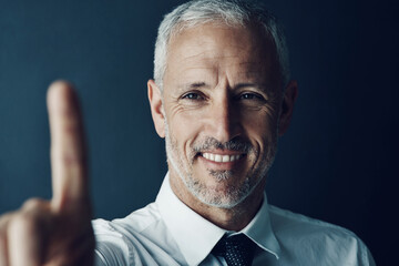 Happy, businessman and touch with finger for interaction, engagement or user experience on a studio background. Face, mature or man with gesture for ongoing development, progress or implementation