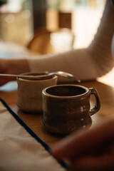 cup ( glay mug) of coffee and hand