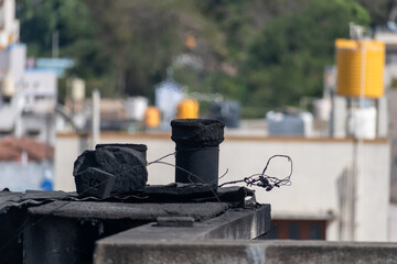 Rooftops of a city showcase remnants of old chimneys and tangled wires, highlighting the...