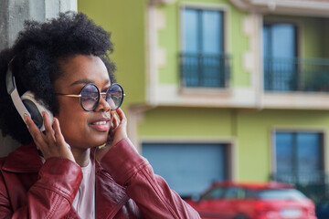 afro american  woman with headphones outdoors on the street
