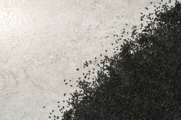 Pile of black sesame seeds on stone texture background