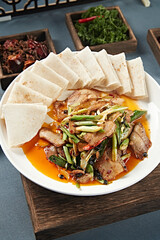 Stir-fried pork with black bean and garlic sprouts served with rolls