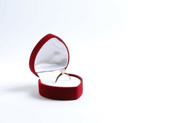 Beautiful shiny gold engagement ring with large diamond gemstone in a rich red velvet box on white...