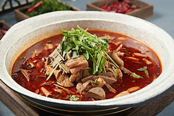 Spicy lamb offal soup in stone pot with red oil