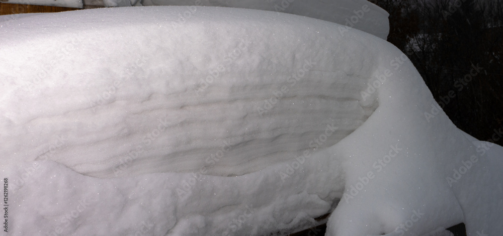 Poster a snow covered bench with a snow pile on top of it