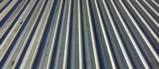 Fototapeta premium Close-up view of a textured metal surface showing parallel lines and shadows, conveying industrial aesthetics and modern design