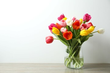 Fototapeta premium Beautiful fresh tulips in vase on the table