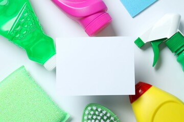Many different cleaning products with white paper card on light background, top view