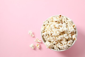 Popcorn in a bowl on color background