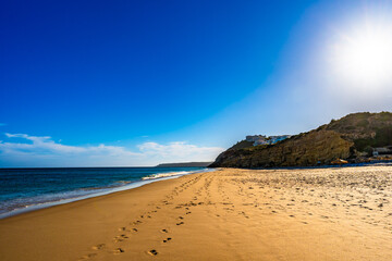 Empty Amado beach in Portugal. Beautiful Algarve coast. View at sunny and sandy beach and cliff