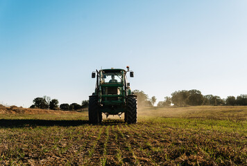 Farmer driving tractor spreading fertilizer on agricultural field