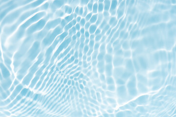 Blue water with ripples on the surface. Defocus blurred transparent blue colored clear calm water surface texture with splashes and bubbles. Water waves with shining pattern texture background.