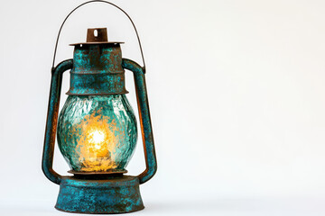 Naklejka premium Vintage blue-green lantern with glowing light, showcasing weathered texture and rustic charm on a plain background.