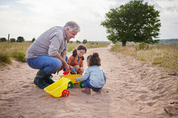 Grandfather, children and playing with toys outdoor for bonding together, fun game or cognitive...