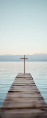 Fototapeta premium Cross at the end of a dock over lake waters