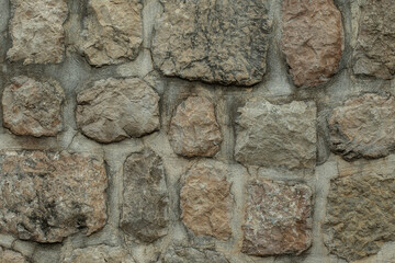 Stone wall background, square shaped stones with cement joints. High quality photo