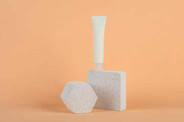 Plastic white tube for cream or lotion. Skin care or sunscreen cosmetic on cream background.