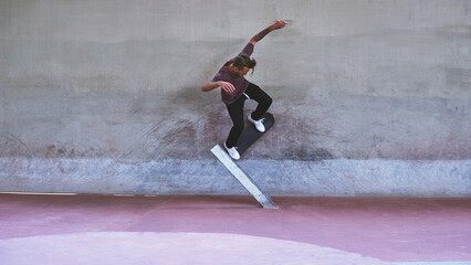 Culture, skateboard and wall with man at park for urban, extreme sports and trick flips. Street league, balance and fitness with person and skating for grind in city with youth, energy and hobby