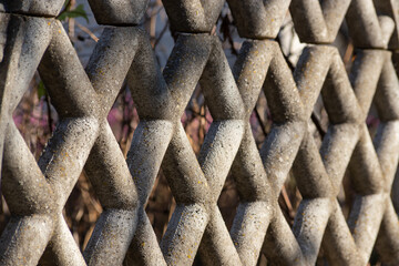 Textured concrete fence with hexagonal patterns creating intriguing visual elements in natural light
