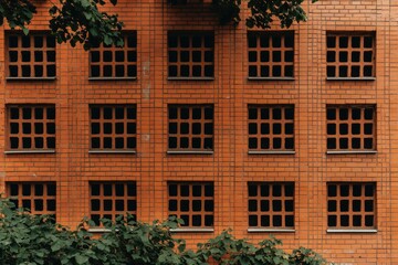 Obraz premium Brick wall with dark windows is a repeating design, and for architectural pattern
