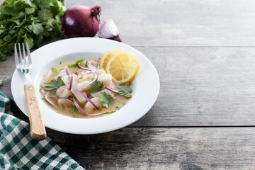 Traditional Peruvian ceviche sea bass fillet on wooden table. Copy space