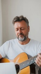 Obraz premium Musician enjoying a moment of creativity while strumming an acoustic guitar indoors