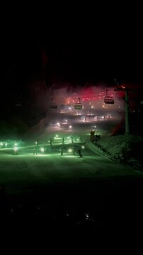 Es un espectaculo de luces que bajan en la monta&ntilde;a con sus distintos colores. Preparando Cortina Italia 2026 en una pista de esqu&iacute; para esquiar y hacer snowboard.