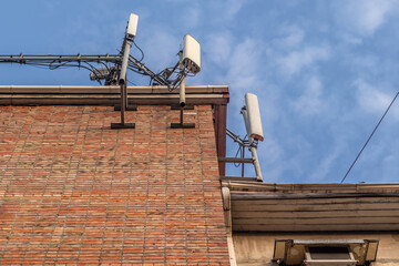 Antennas for mobile telephony on the roof of a residential building and blue sky