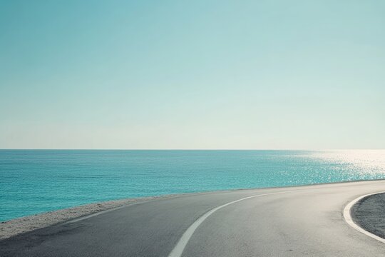 Winding road curves to turquoise sea; vast horizon; sunny day; travel inspiration