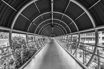Infinity End.  Long raised walkway with circular metal rails supporting the ceiling in Bangkok.