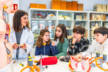 Teacher explaining human anatomy to elementary school students in science class