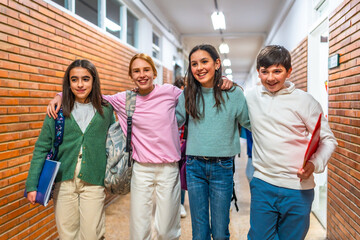 Happy students walking down school hallway together