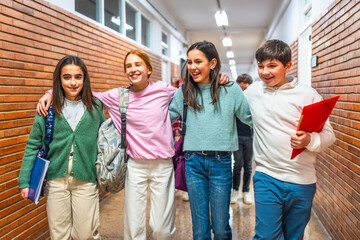 Happy students walking in school corridor together