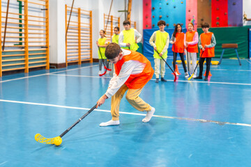 Students playing floorball in gym class at school