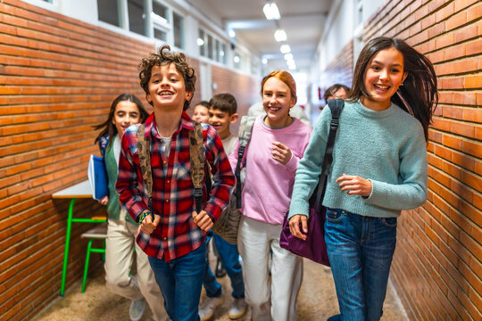 Group of elementary school students running in school hallway