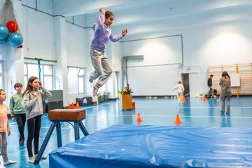  Young girl performing gymnastics vaulting in school gym class © unai