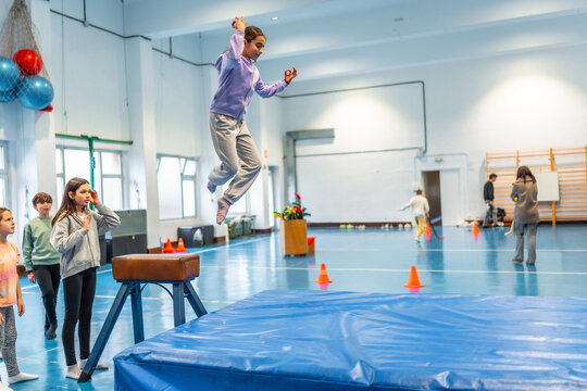 Young girl performing gymnastics vaulting in school gym class