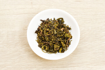 Dried tea leaves on bowl, copy space
