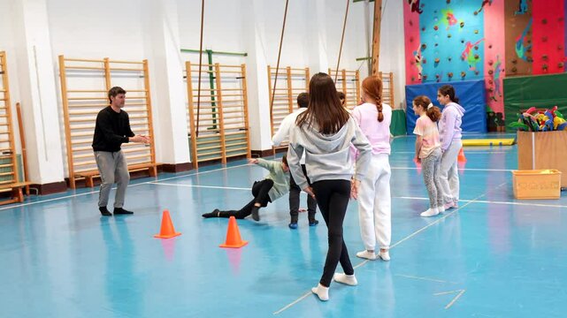 Teenage students engaging in dynamic dodgeball match during high energy physical education class, demonstrating teamwork and competitive spirit in school gymnasium