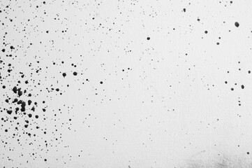 gray background, photograph of black paint splashes on white wall