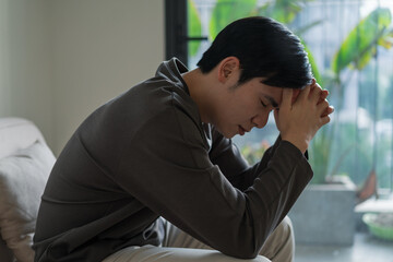 Young Asian man feels lonely and tired