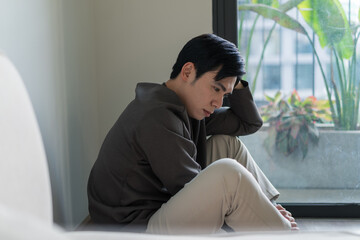 Young Asian man feels lonely and tired