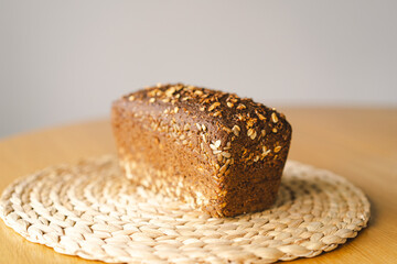 Sourdough bread, freshly baked and still warm, are stacked on a wooden surface. The bread are...