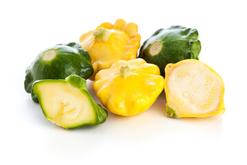 green and yellow pattypan squashes on white background