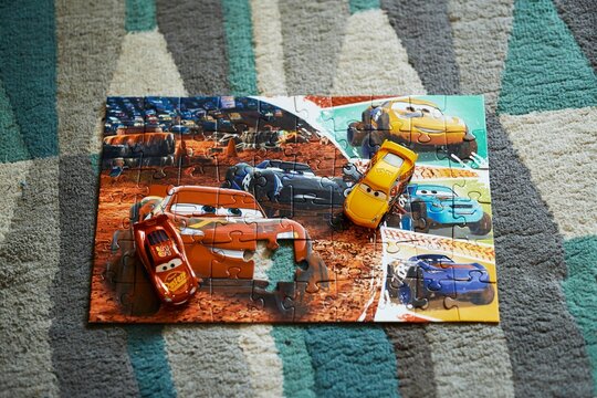 Mattel Cruz Ramirez and Lightning McQueen on a Trefl Disney Pixar Cars puzzle.