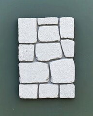 Textured White Stone Wall Panel Against Green Background