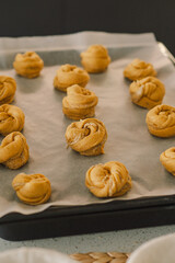 A woman in casual attire prepares dough for baking. She looks pleased and focused, enjoying the baking process in a light-filled kitchen.