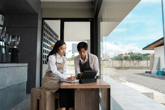 Cafe staff discussing plans and reviewing data on a tablet