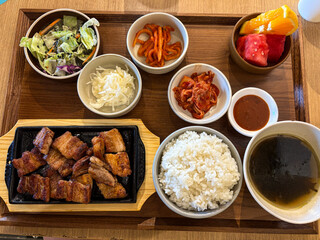 A set meal of pork belly, rice, and vegetable side dish.